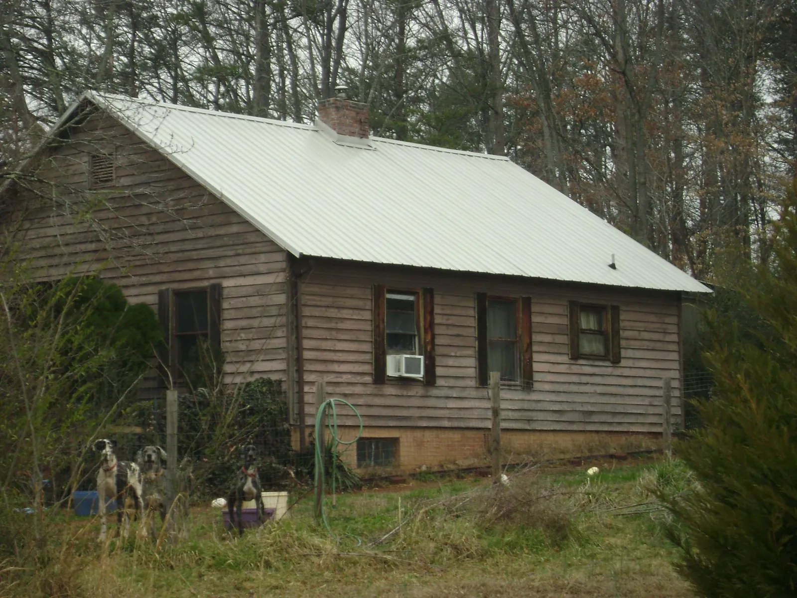 White metal roof on an old wood sided farmhouse, from a Metal Roof Installation job in Wilder